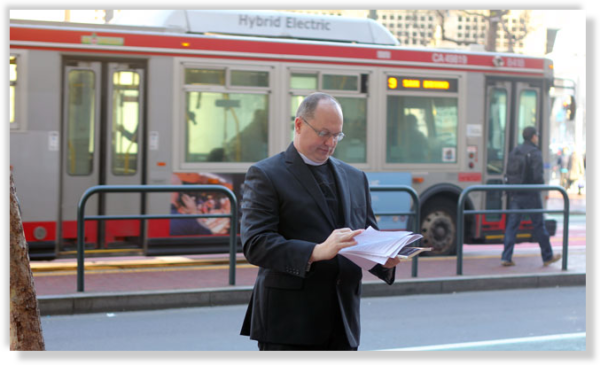 startup priest reading api docs outside twitter in san francisco